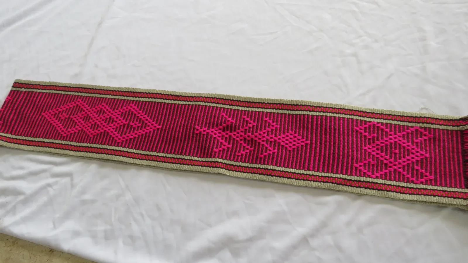 Chumbe fucsia con rombos y figuras escalonadas