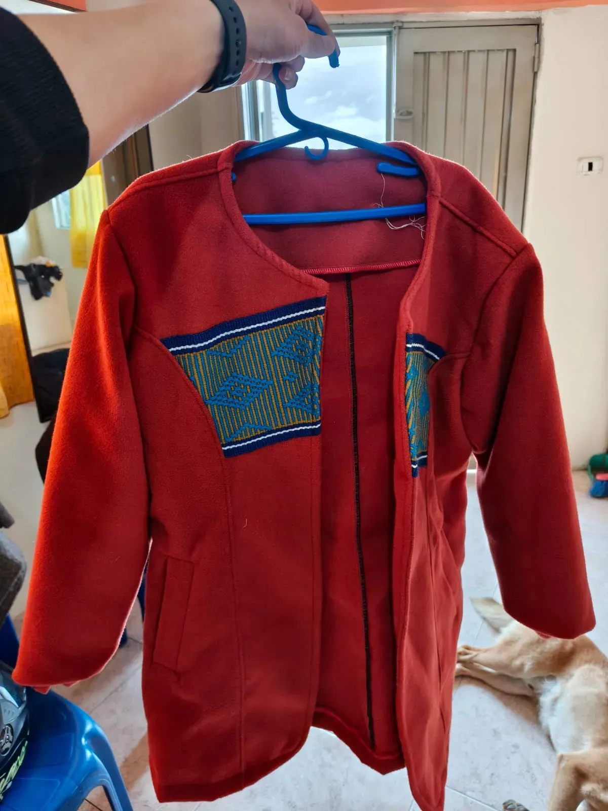 Detalle de la aplicación tejida sobre el saco rojo