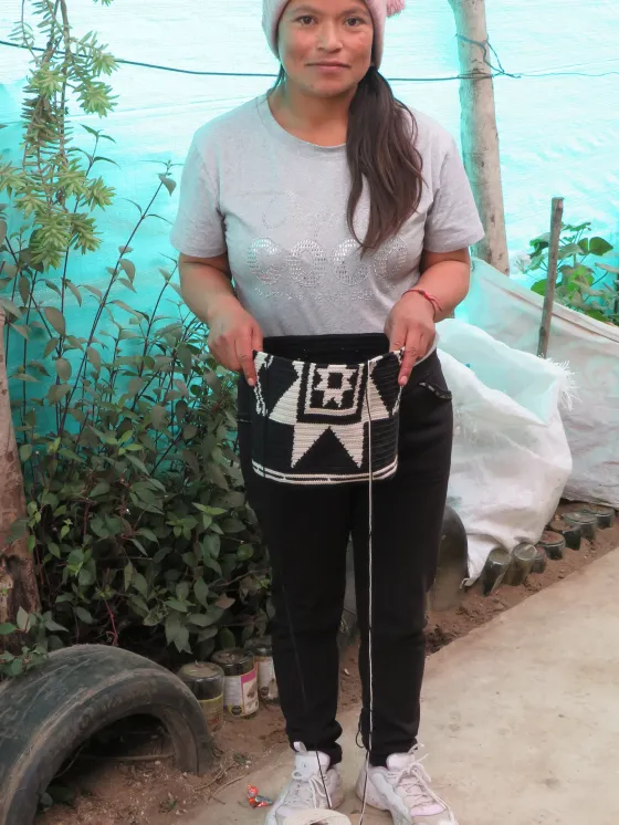 Tejedora de la asociación con una mochila del grupo